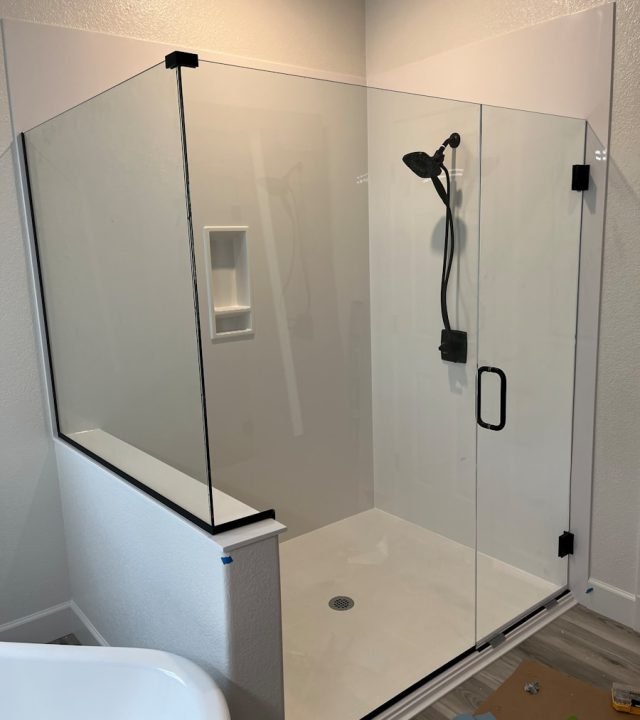 a bathroom with a glass shower door and a tub