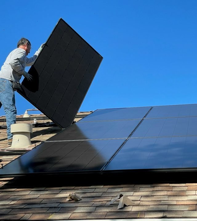 man in white dress shirt and blue denim jeans sitting on white and black solar panel